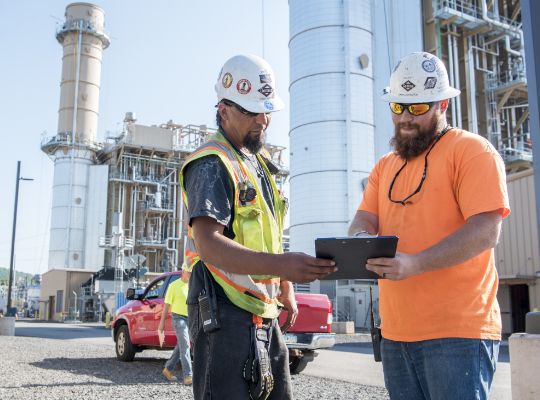 two men looking at a clipboard